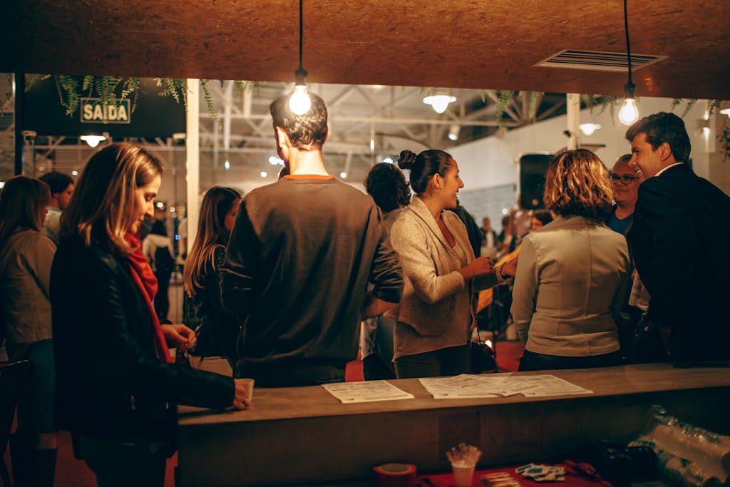 A lively indoor social gathering with people interacting warmly under cozy lighting.